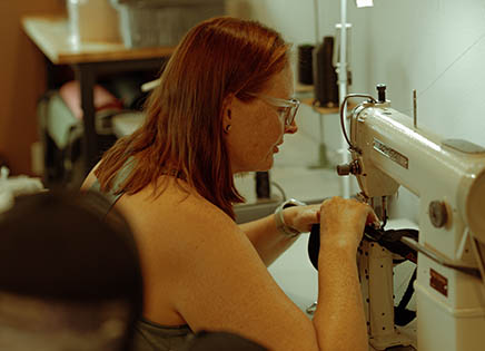 woman stitching a hat using a sowing machine