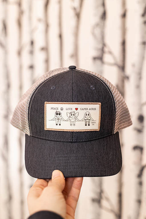 hat with the text peace love caper acres on it